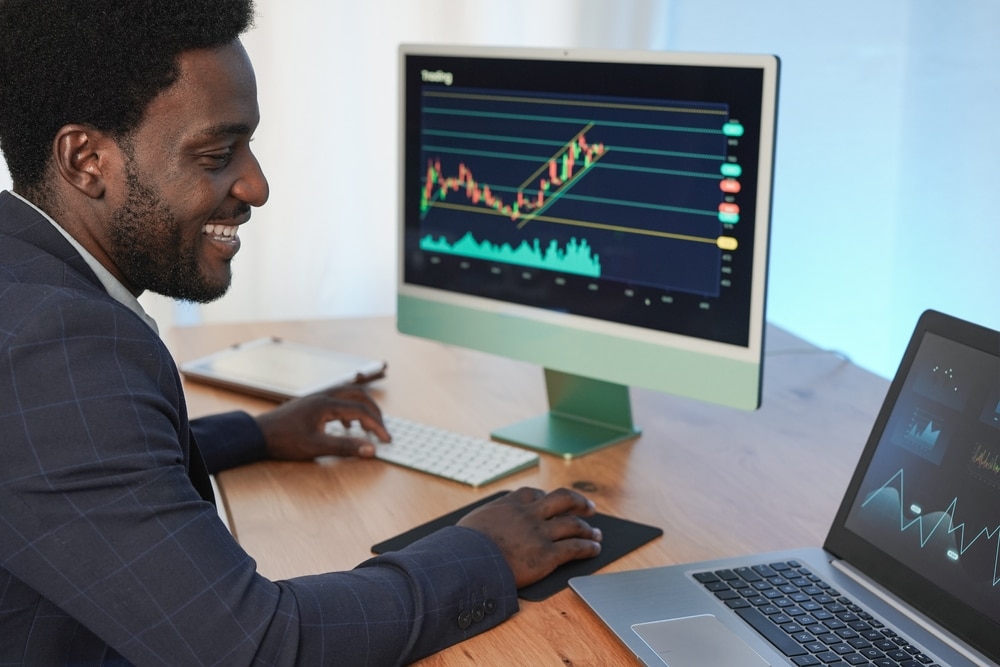 African,Trader,Man,Using,Laptop,,Computer,And,Tablet,While,Working