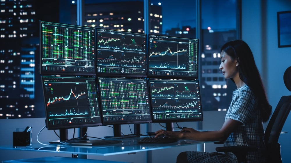 Financial,Analyst,Working,On,A,Computer,With,Multi-monitor,Workstation,With